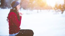 Woman doing yoga outside in the snow