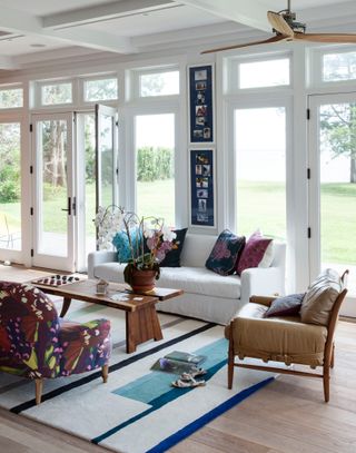 White living room with French doors and colorful rugs and accessories