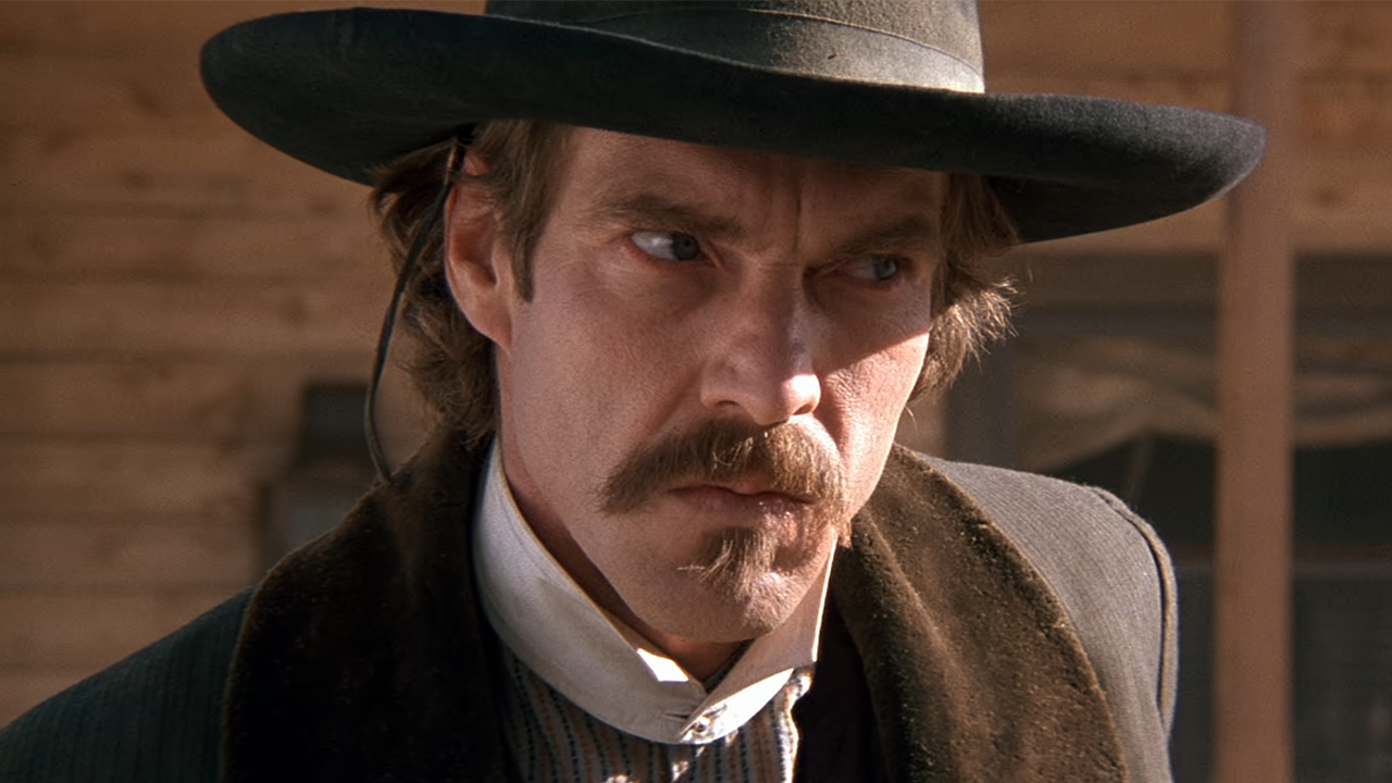 A close up of Dennis Quaid in a hat in Wyatt Earp