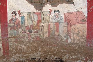 The murals on the west wall of the 1,000-year-old tomb depict articles of clothing as well as two servants.