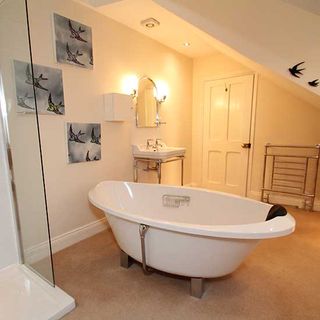 bathroom with polished flooring white walls and white bathtub