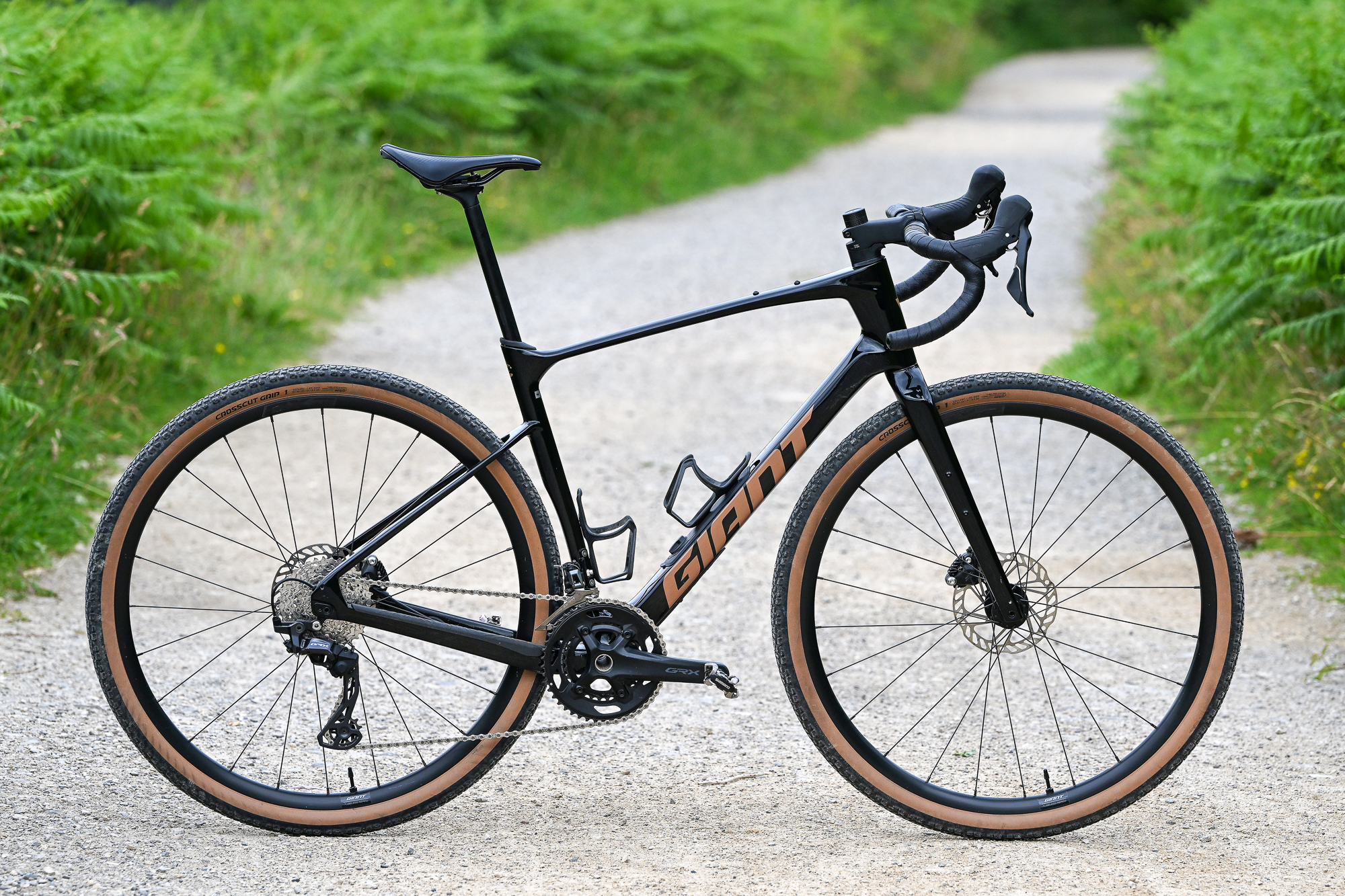 a black gravel bike standing up on its own on a gravel trail side on to the camera