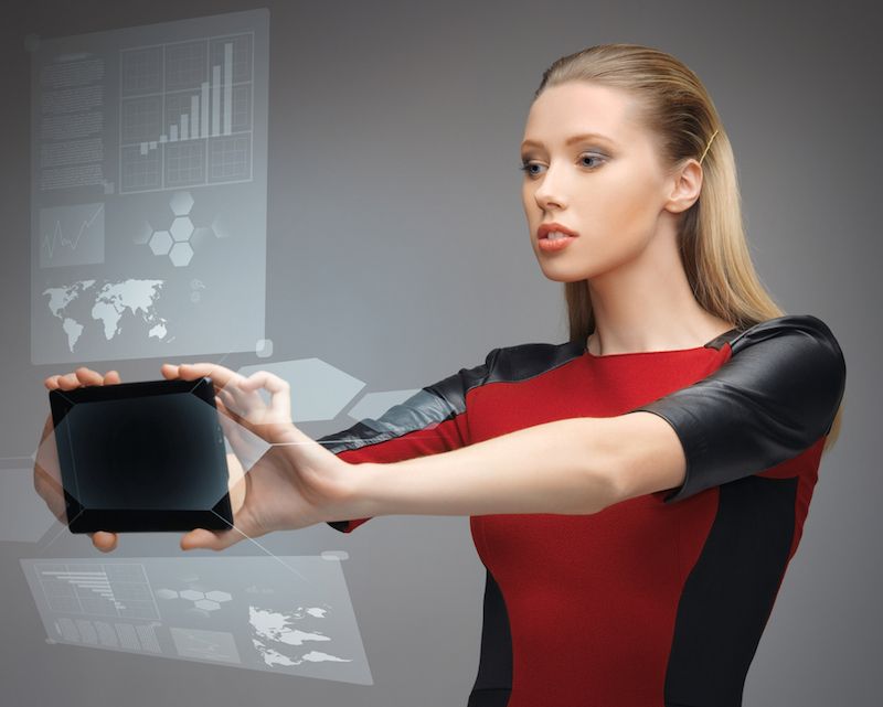 A futuristic looking woman studies a hologram on a tablet screen.