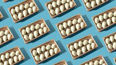 A repeating pattern of eggs in baskets against a blue background.