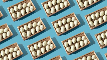 A repeating pattern of eggs in baskets against a blue background.