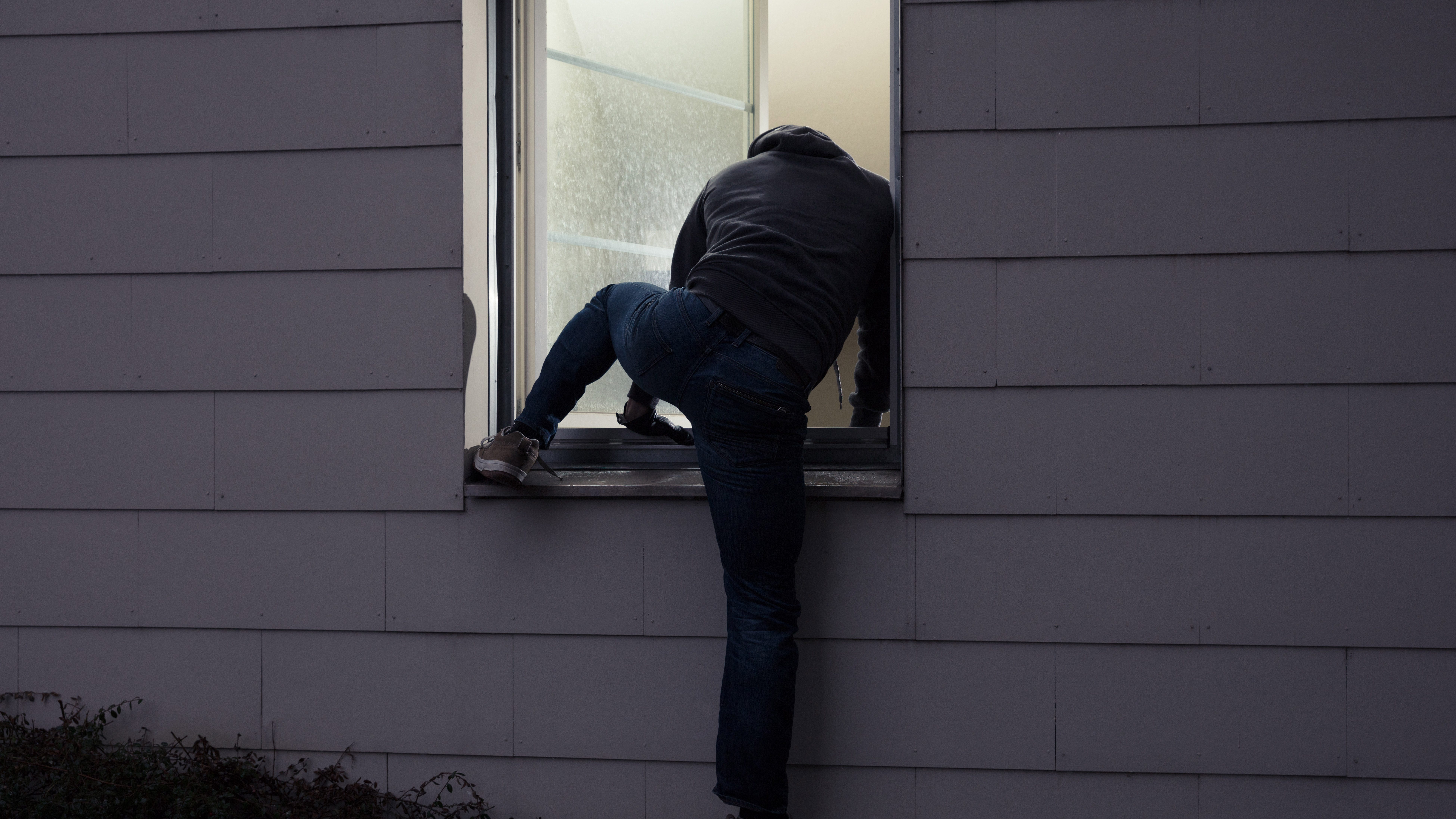 Burglar breaking into a home