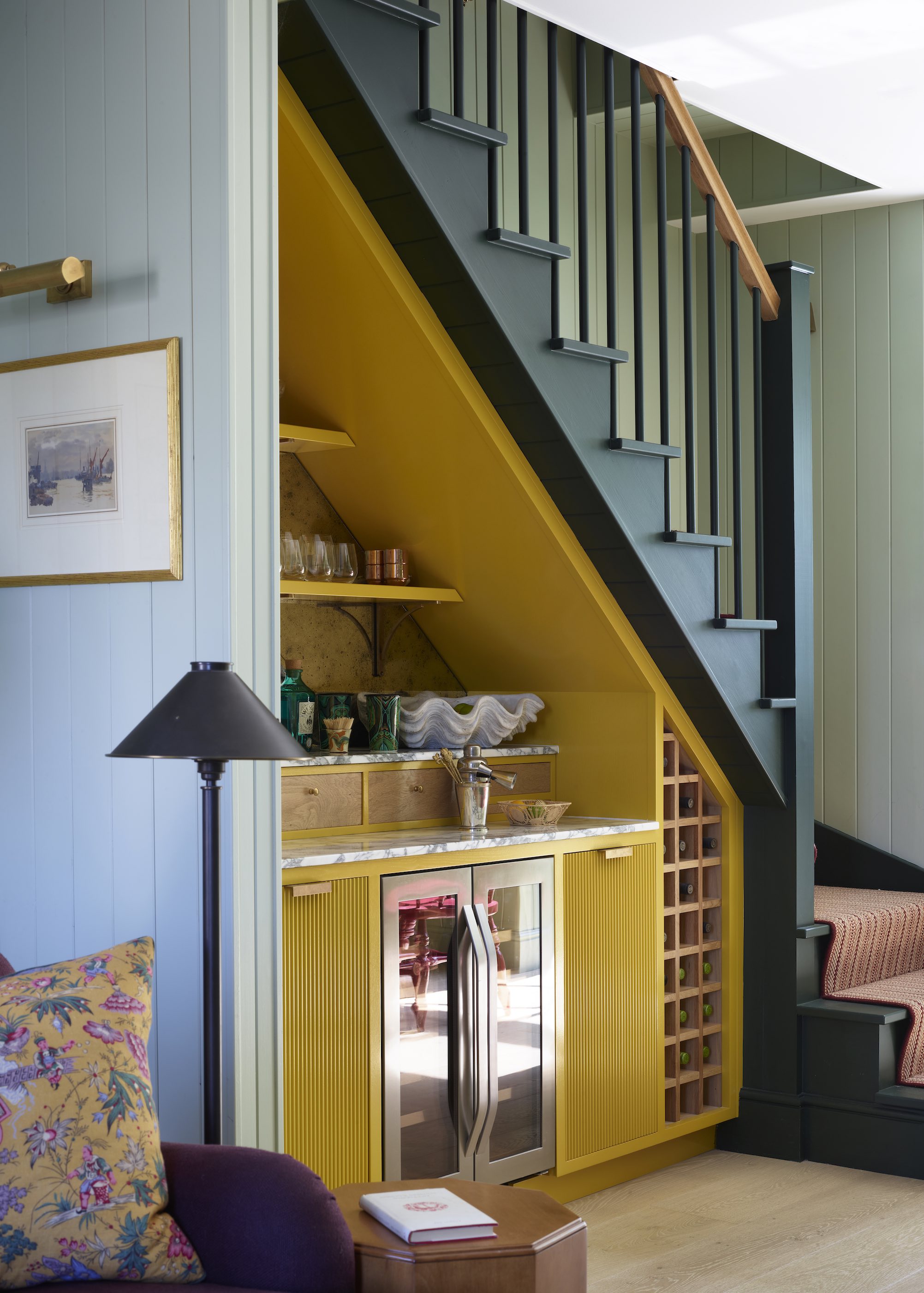 staircase with bar underneath with lots of glassware and bar essentials