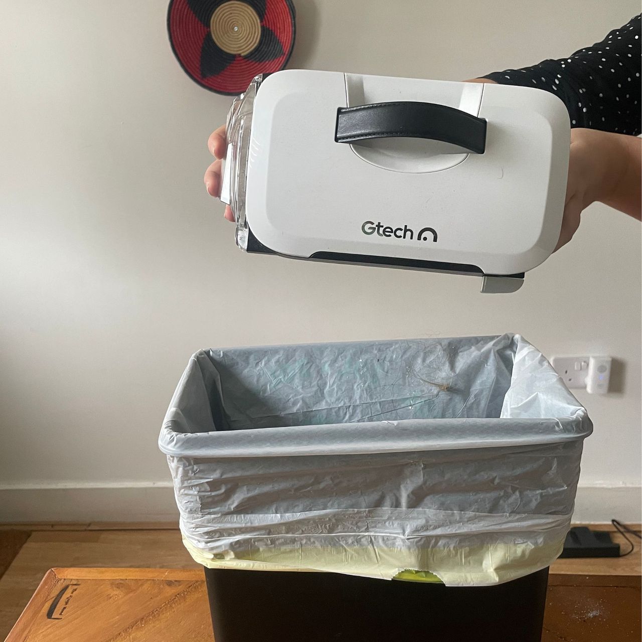 Gtech AirRam 3 emptying over a kitchen bin