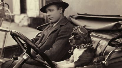 Sepia image of Jiggs the famous movie dog driving a vintage car