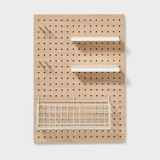 Wooden pegboard with storage shelves and baskets.