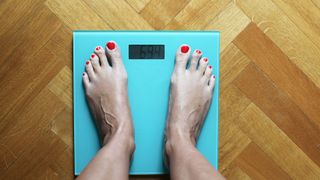 Does running burn fat? Image shows feet on weighing scales.