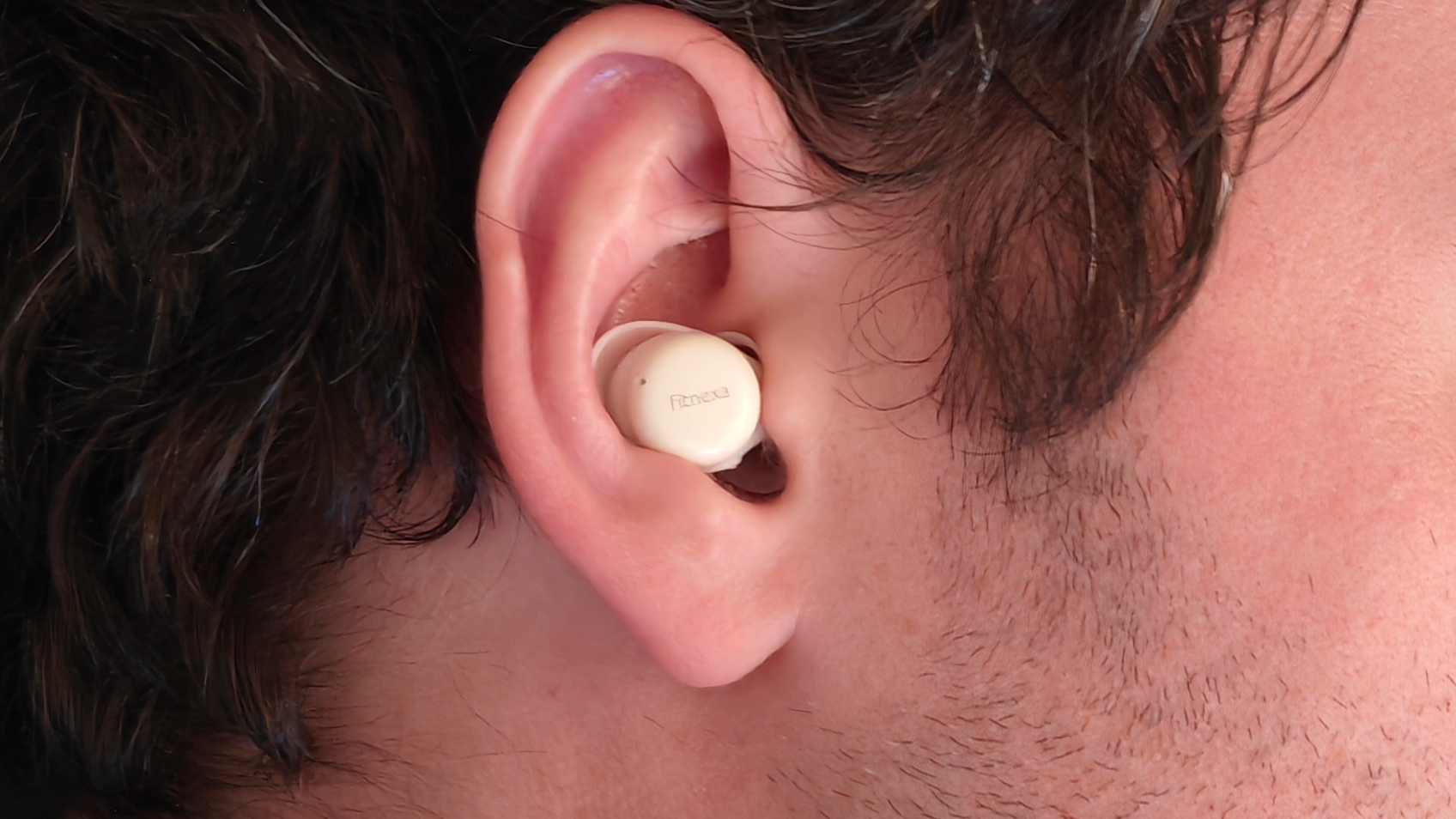 The Fitnexa SomniPods 3 earbuds in a man's ear.