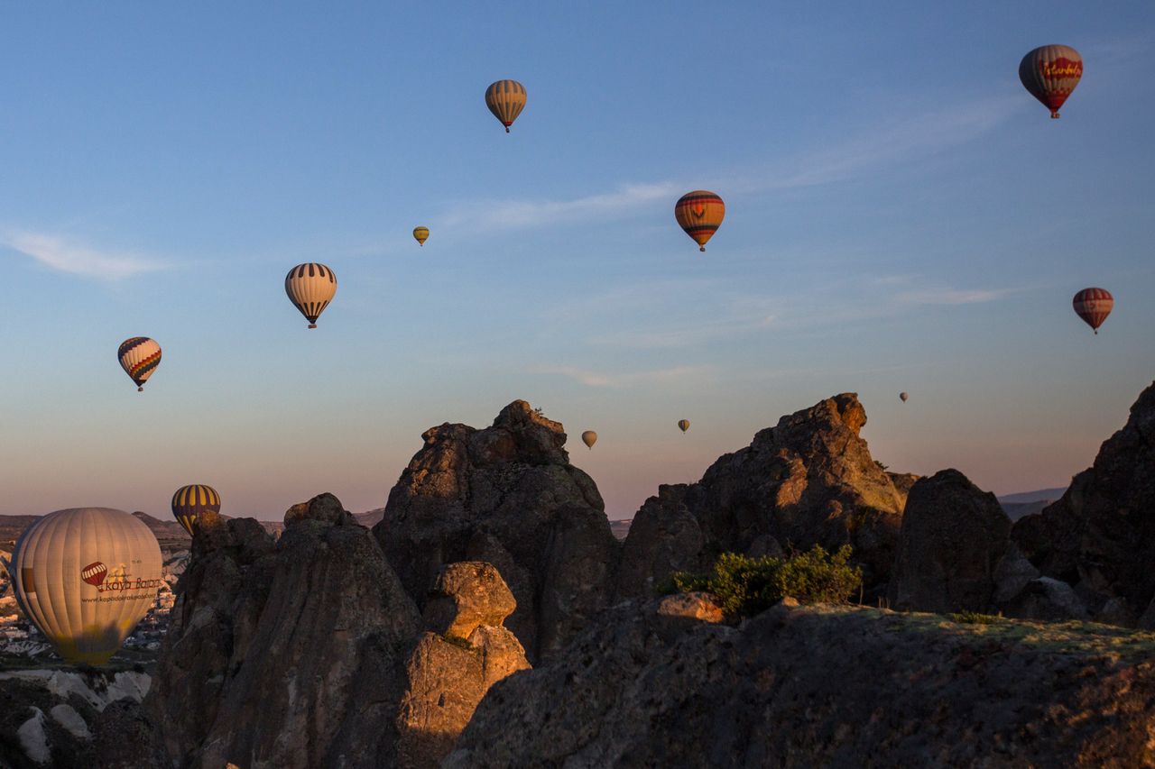 Hot air balloons fly over the rock formations in Cappadocia, Turkey