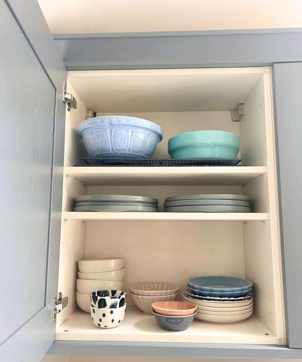 After, a much tidier kitchen cabinet with perfectly stacked plates, bowls and side plates