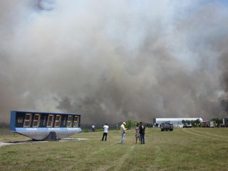 A brush fire near NASA's Kennedy Space Center press site casts off thick smoke on April 27, 2011 as the space agency prepares to launch the space shuttle Endeavour's STS-134 mission from the nearby Launch Pad 39A. Liftoff is set for April 29.