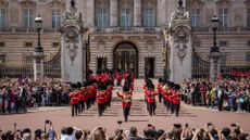Tourists watch the Changing of the Guard outside Buckingham Palace