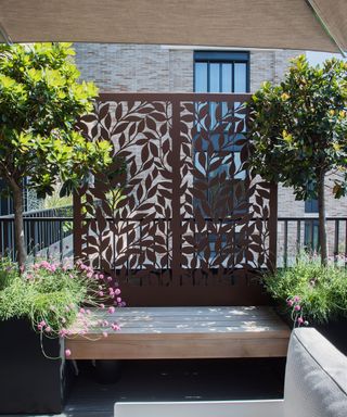 decorative metal screen adding privacy to a balcony garden