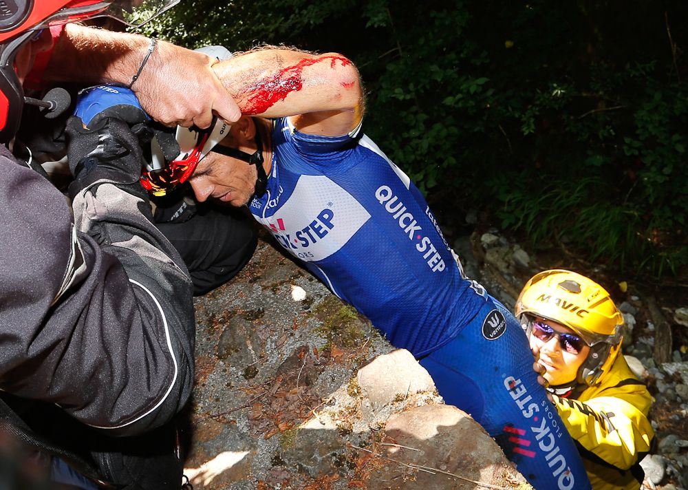 Philippe Gilbert is helped back up to the road after crashing during stage 16 at the Tour de France