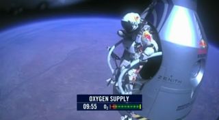 Felix Baumgartner stands poised on the edge of his capsule, preparing to leap from higher than any skydiver before.