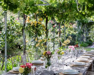 alfresco dining table with flowers, linen and china