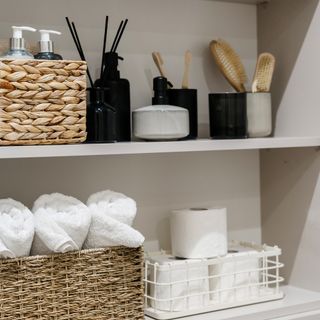closeup of a bathroom shelf with matching towels, accessories and baskets