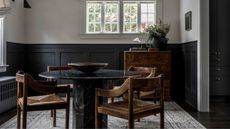 Dining room with half panelled walls painted in dark gray