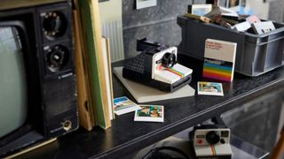 Lego Polaroid OneStep camera set on a shelf alongside older tech