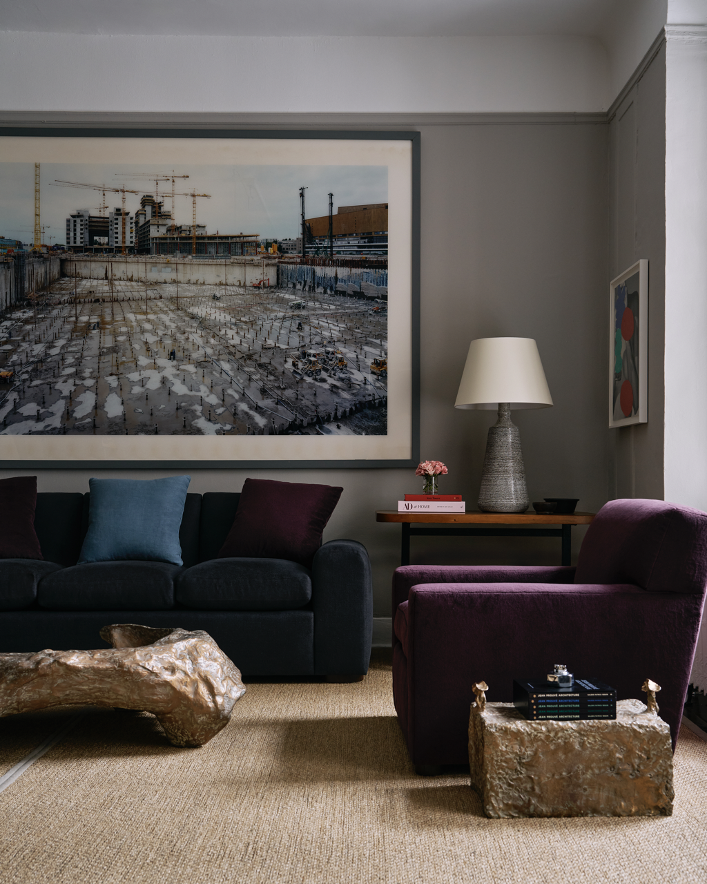 An image of Robert Stilin's shop, including a portrait of Stilin holding his latest book, an image of a wall with a credenza and hanging art, and a corner including an purple armchair and a couch.