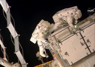 NASA astronauts Shane Kimbrough (left in red stripe) and Peggy Whitson work retrieve adapter plates outside the International Space Station during a Jan. 6, 2017 spacewalk to upgrade the orbiting laboratory's power system.