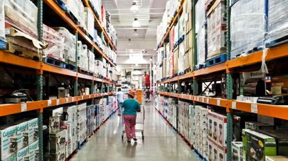 a female shopper walks the aisles of warehouse retailer COSTCO