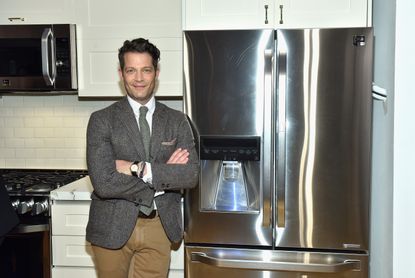 Nate Berkus poses in front of a fridge 