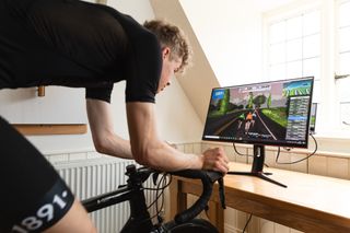 Image shows a person training on the bike alongside gym work