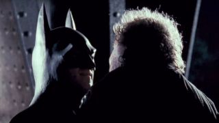 Michael Keaton as Batman strong-arming a thug in Batman