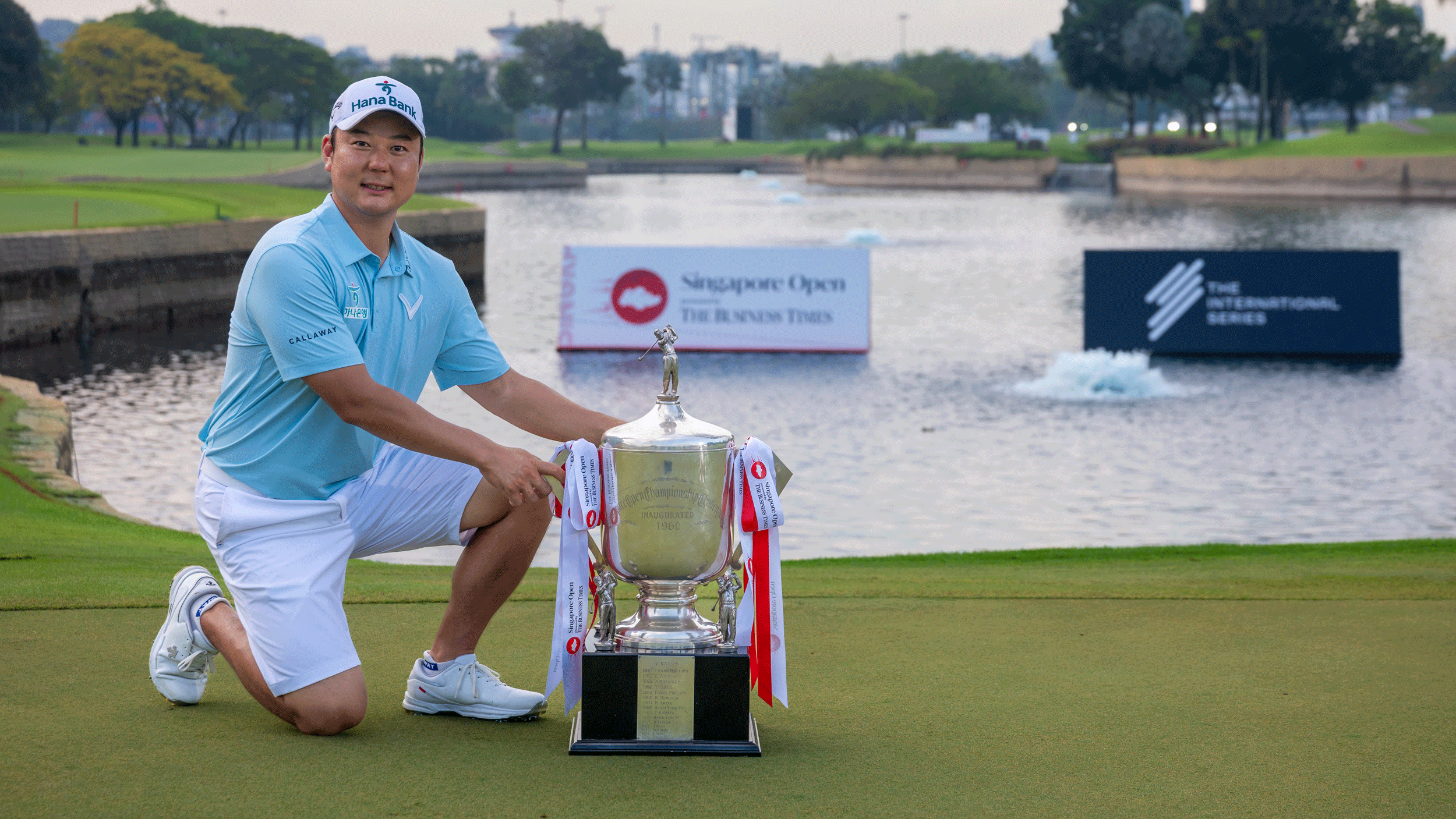 Jeongwoo Ham kneels down next to the Singapore Open trophy following his win in 2026
