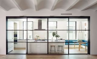 The steel and glass pocket door allows light to flood the loft, even while the open plan space is divided