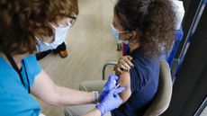 A health care worker administers a dose of the Pfizer-BioNTech COVID-19 vaccine to a teenager at Holtz Children's Hospital in Miami, Florida, on May 18, 2021.