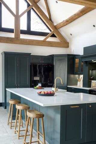 green kitchen with oak frame vaulted ceiling