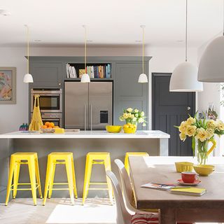 kitchen with worktop and yellow bar stools
