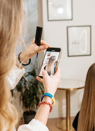 Woman taking a picture at a hair salon