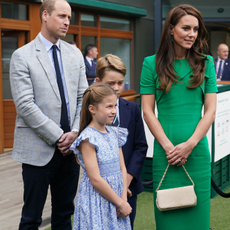 Prince William, Prince of Wales, Princess Charlotte, Prince George and Catherine, Princess of Wales, speak to ball boys and girls as they arrive to attend day fourteen of the Wimbledon Tennis Championships at All England Lawn Tennis and Croquet Club on July 16, 2023 in London, England.