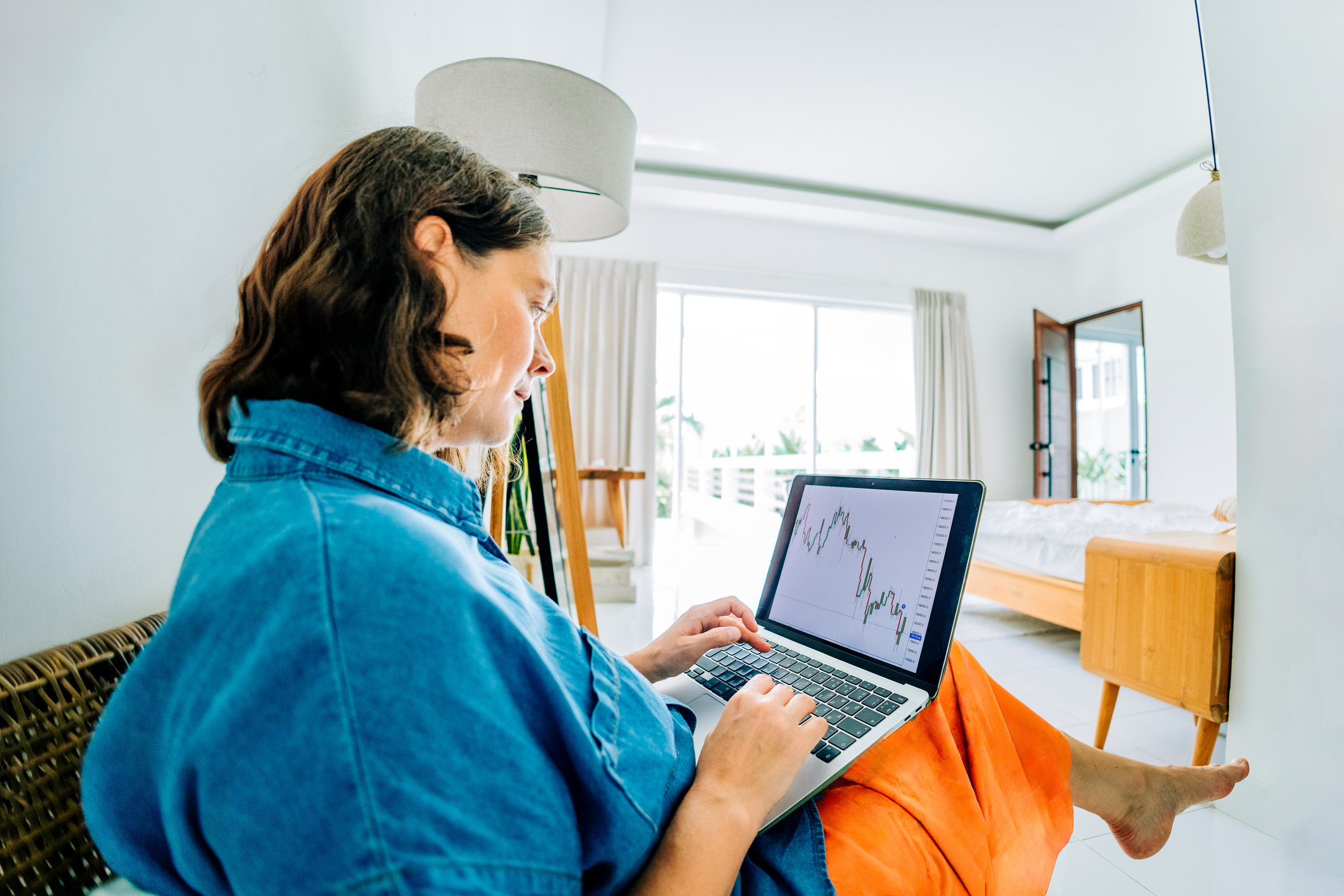Person looks at investing chart on her laptop.