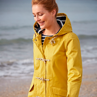 lady with yellow coloured jacket near sea