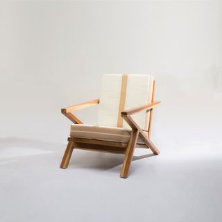 Chair design by Tosin Oshinowo with wooden frame and white upholstered seat and back