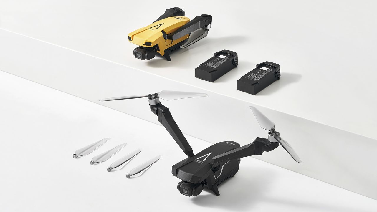V-Copter Falcon Mini drone in black and in yellow, alongside accessories, on a plain white surface