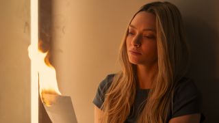 Amanda Seyfried as Nina burning a picture in The Housemaid