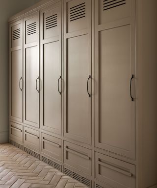 locker cabinetry painted light brown with parquet flooring