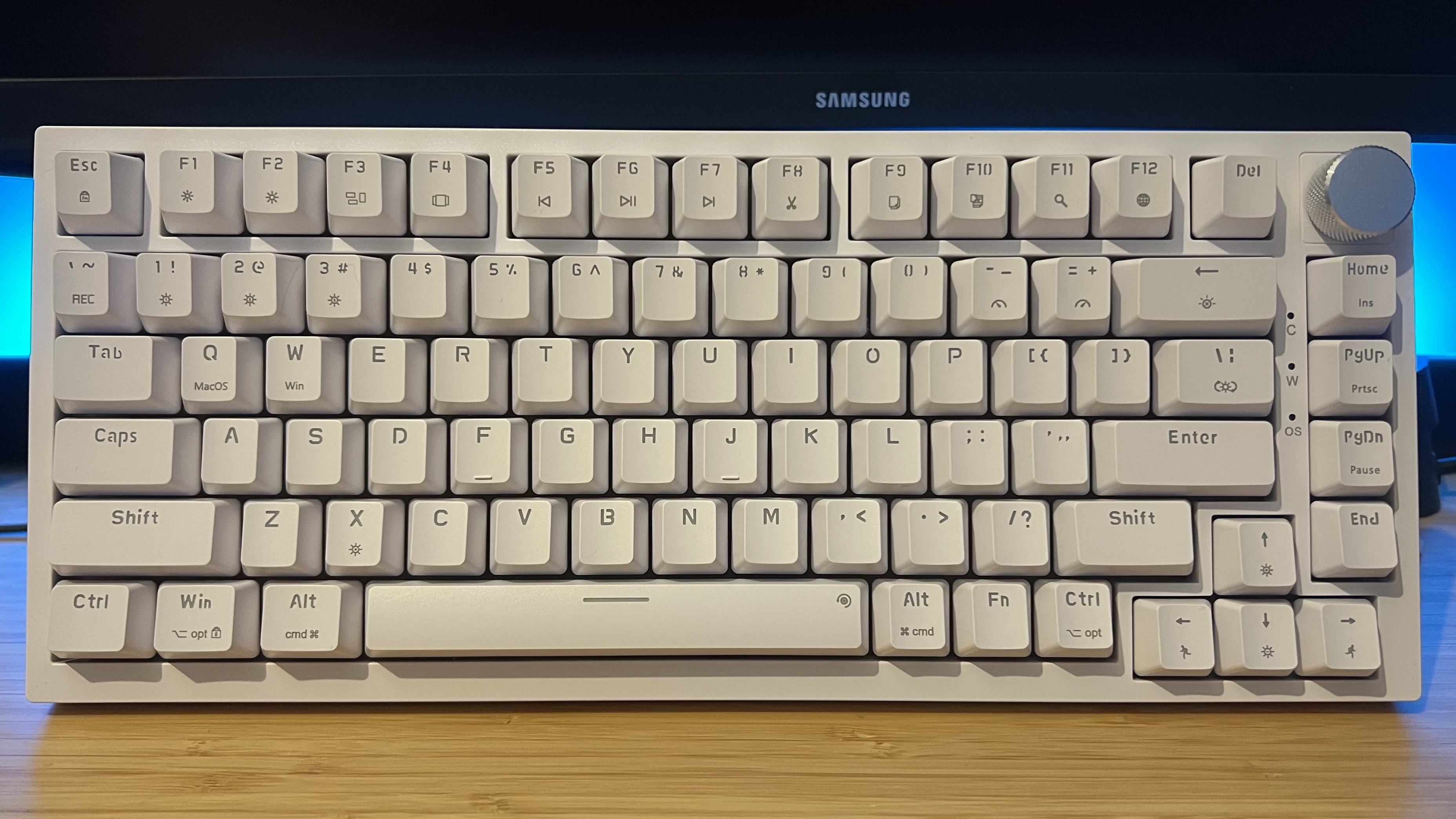 Newmen GM326 gaming keyboard on a wooden desk with blue backlighting