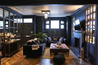 dark blue living room with mirror wall, blue sofas painted woodwork