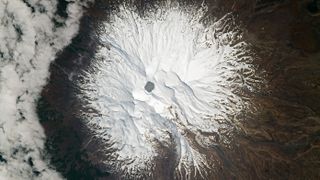 An astronaut photograph of Mount Ruapehu taken on Sept. 23, 2021. The highly acidic hydrothermal lake, known as Crater Lake, can be seen at the summit of the active stratovolcano.