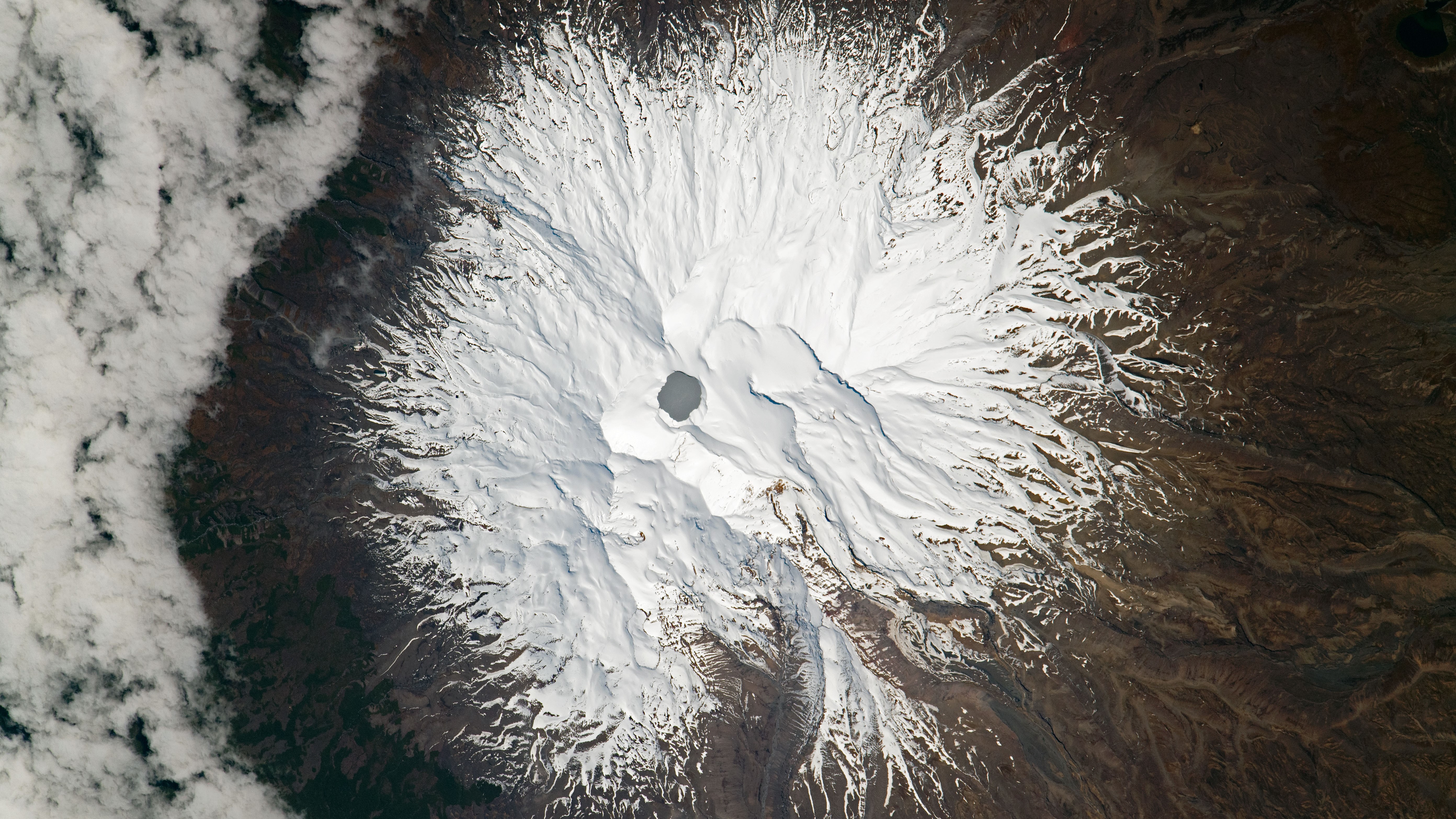 An astronaut photograph of Mount Ruapehu taken on Sept. 23, 2021. The highly acidic hydrothermal lake, known as Crater Lake, can be seen at the summit of the active stratovolcano.